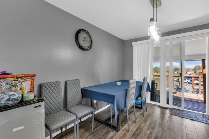 Dining area featuring wood-finish flooring, gray wall paint, and a modern pendant light fixture