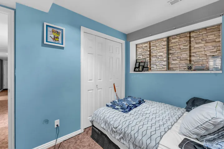 Room featuring a textured accent wall, light blue painted walls, and white trim