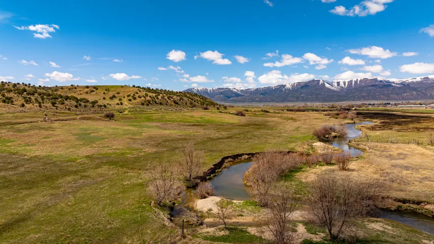 Expansive green and brown fields with a winding river