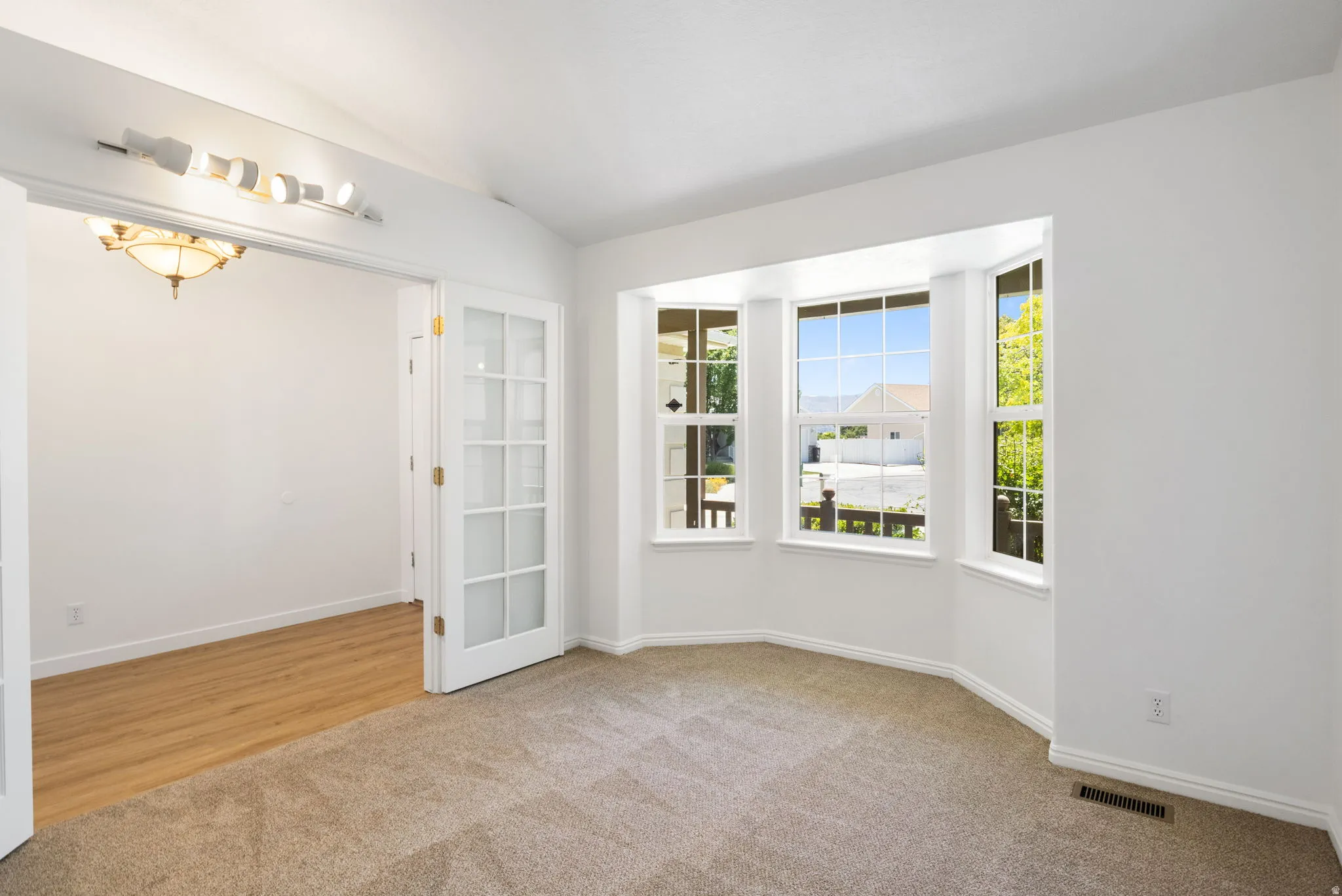 Room featuring a bay window with multiple panes, providing natural illumination