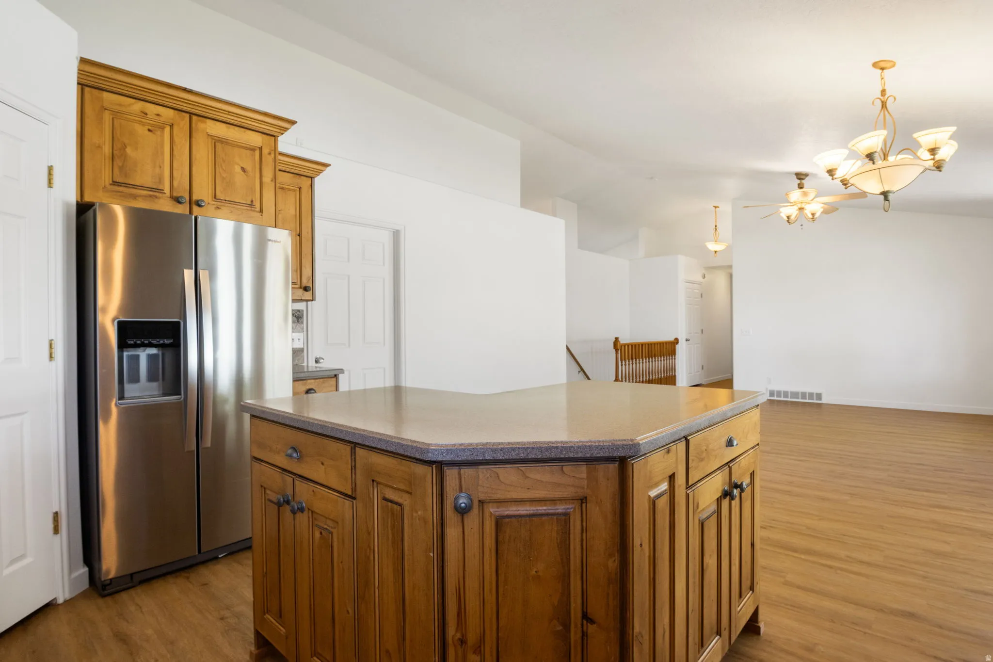 Kitchen island with wood-finish cabinetry and a stone-look countertop