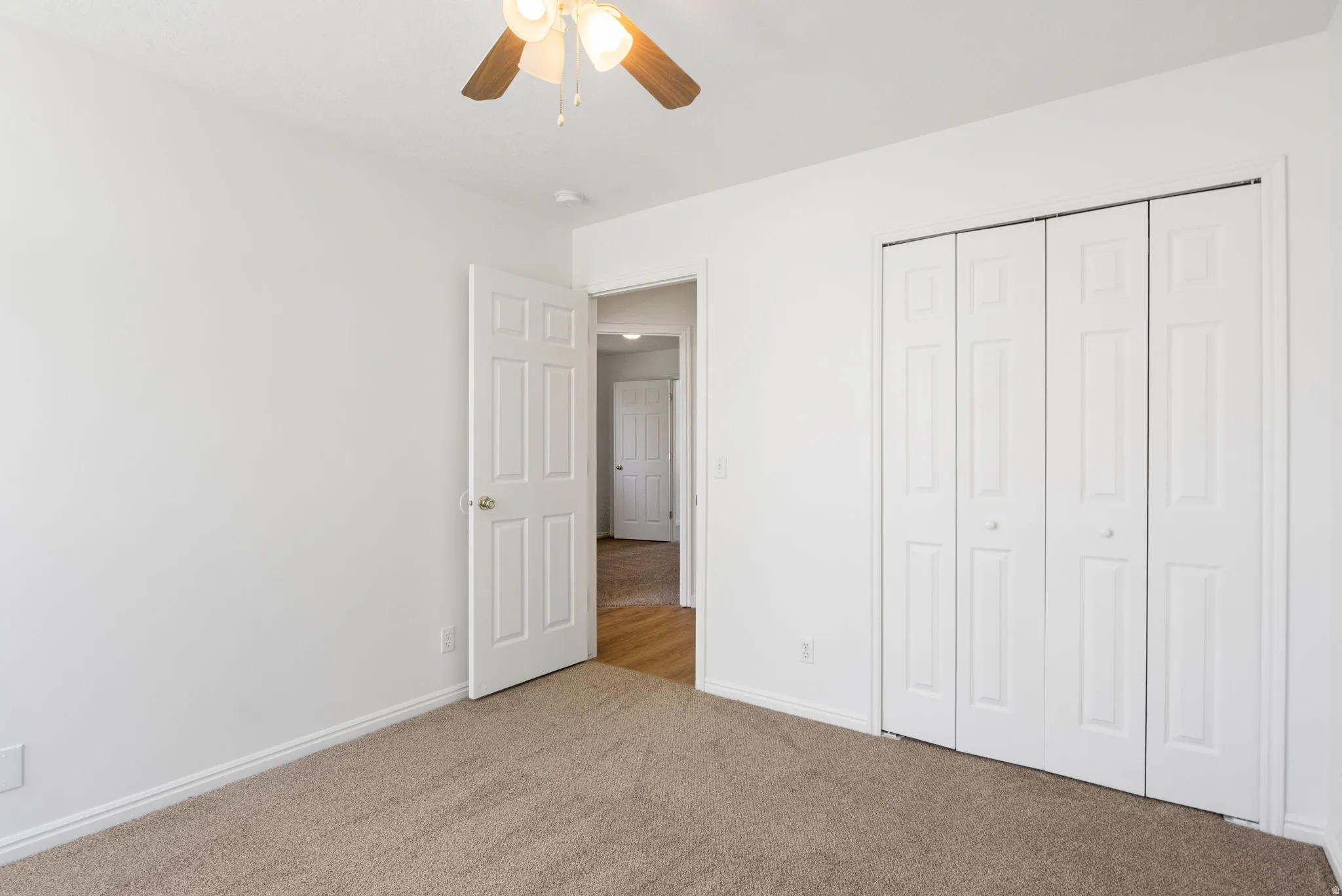 Neutral-toned wall-to-wall carpeting and bright white walls