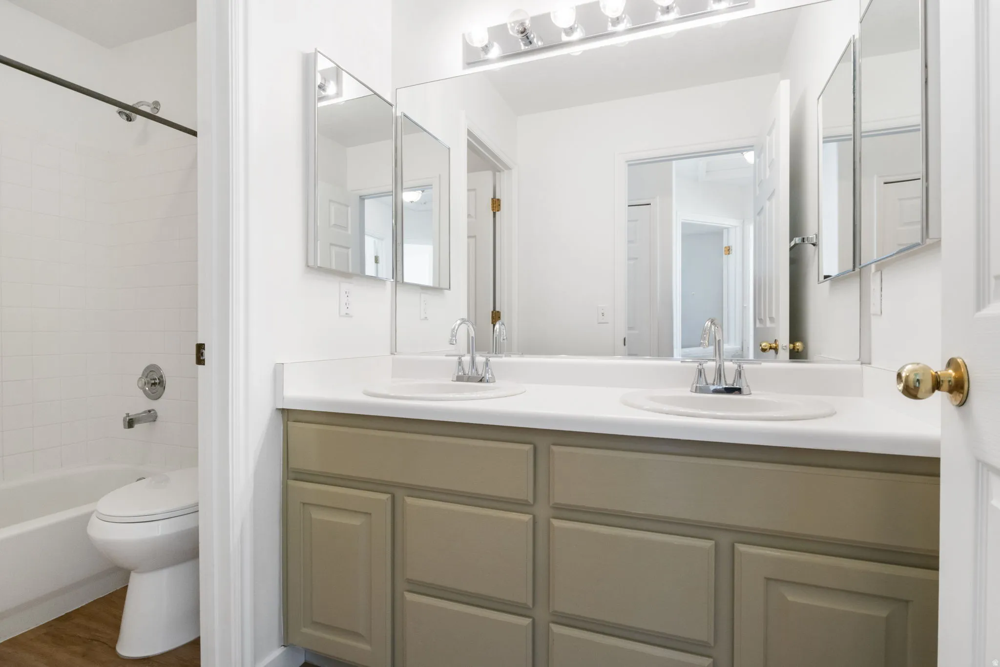 Bathroom featuring a double vanity with an integrated countertop, dual sinks, and chrome faucets