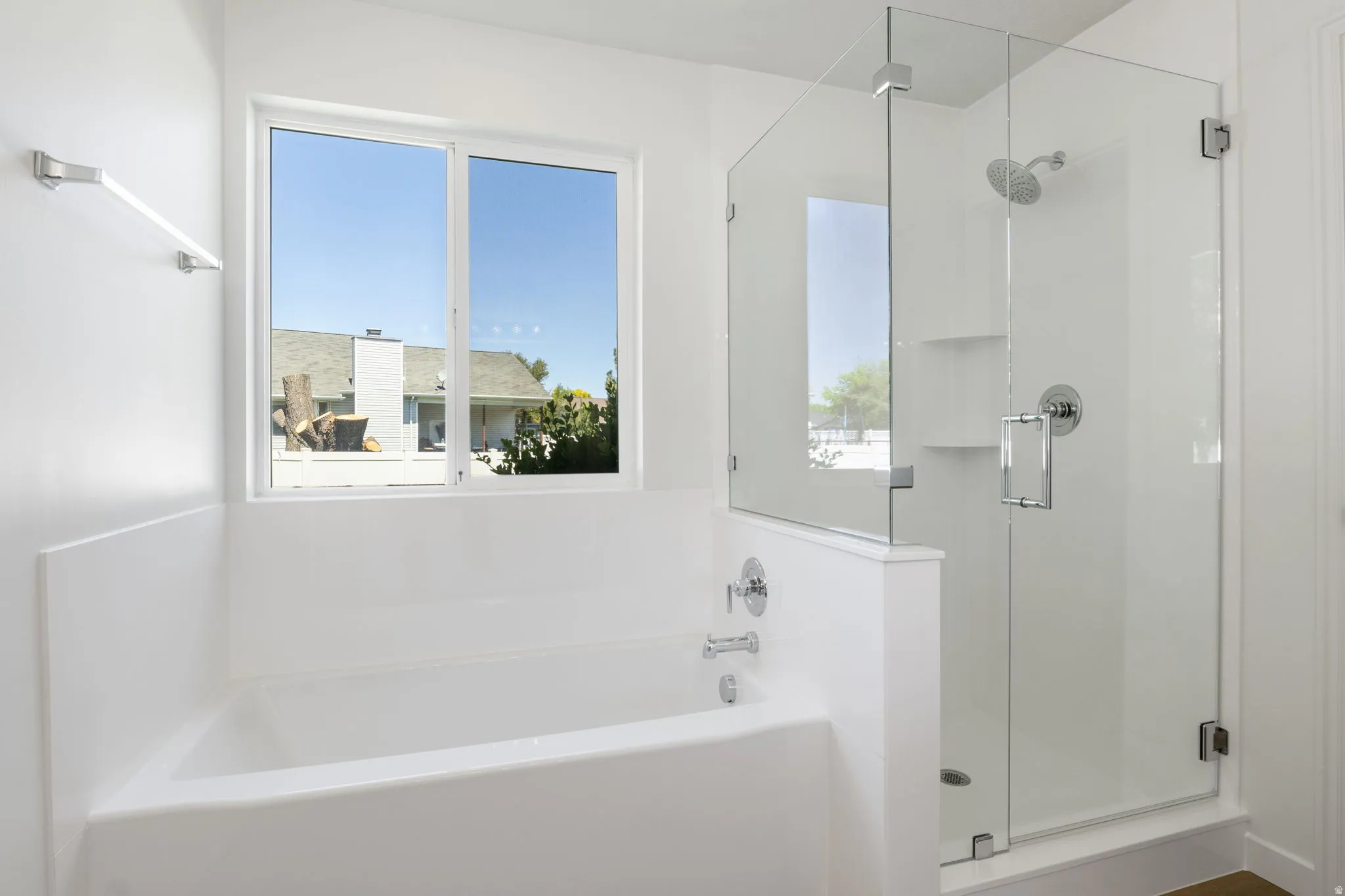 Bright bathroom featuring a soaking tub with chrome fixtures and a large window