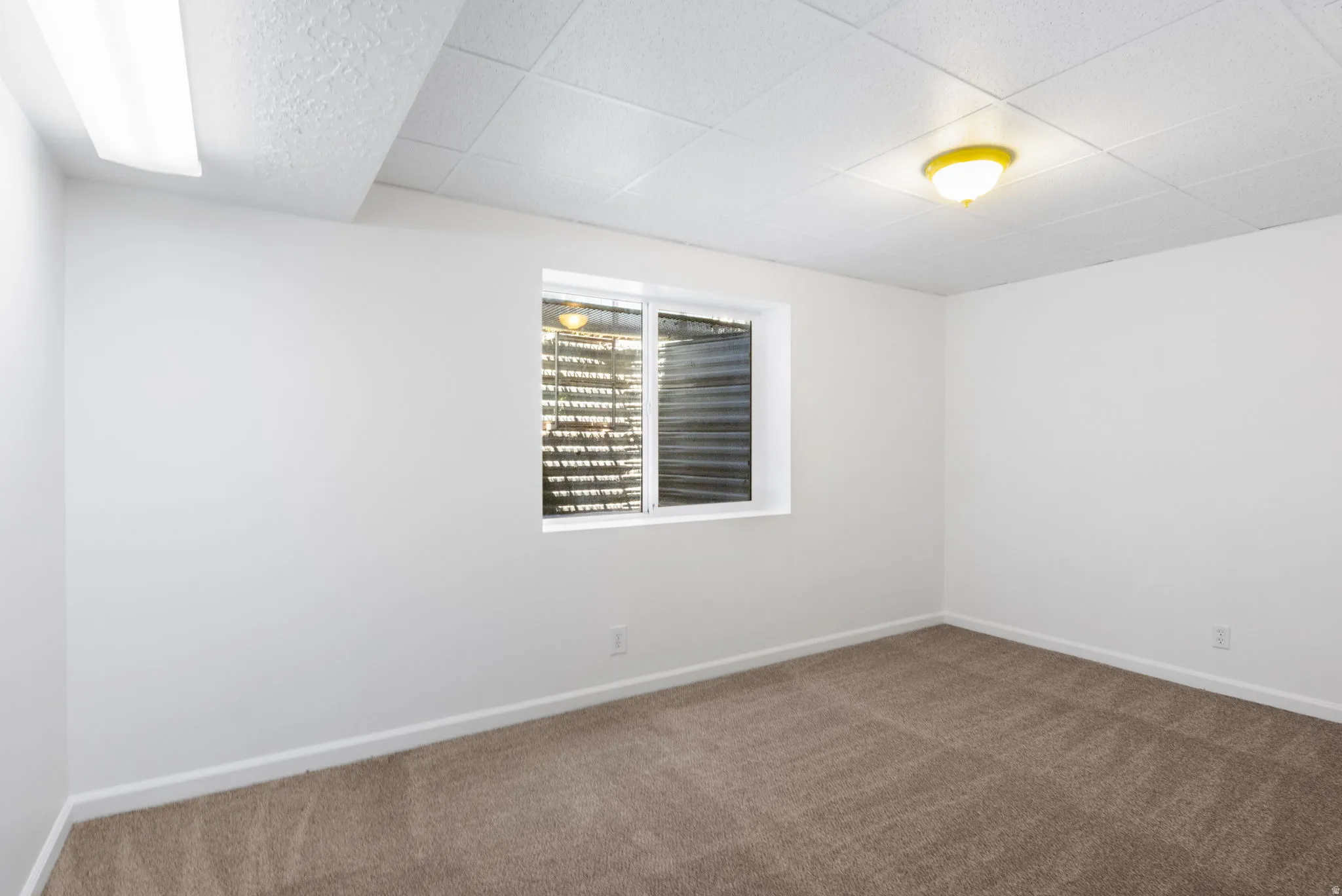 Neutral color palette room featuring a window with blinds, recessed lighting, a ceiling-mounted light fixture, and carpet flooring