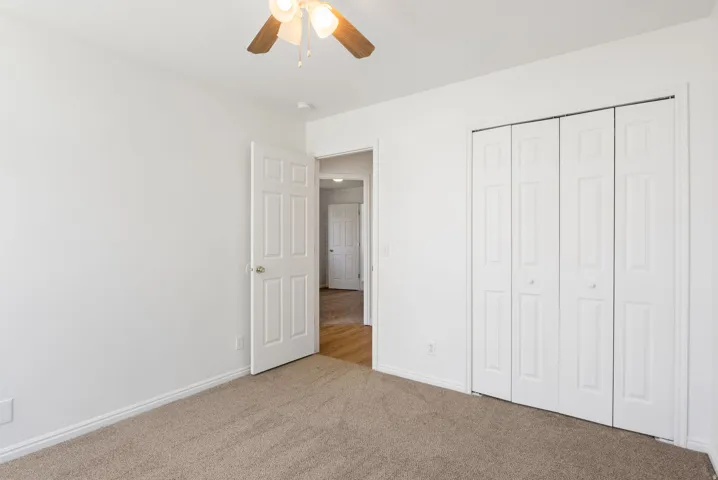 Neutral-toned wall-to-wall carpeting and bright white walls