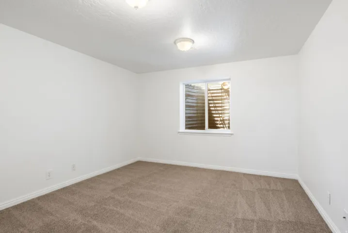 Neutral color palette featuring textured carpeting and white baseboards