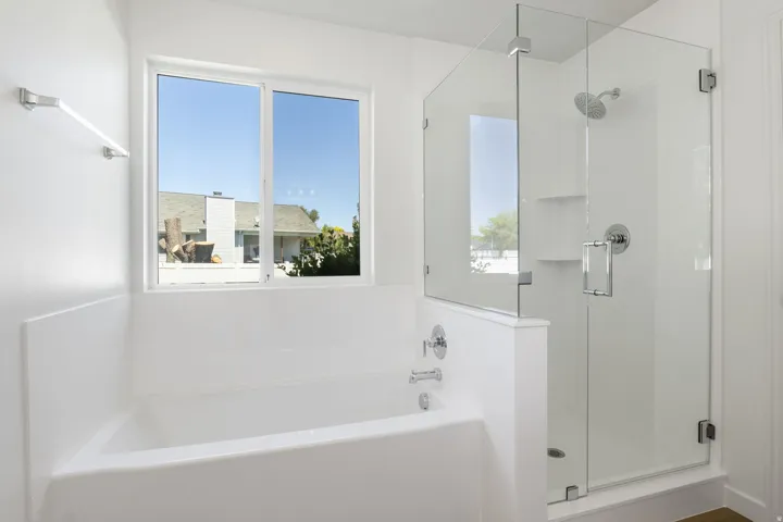 Bright bathroom featuring a soaking tub with chrome fixtures and a large window