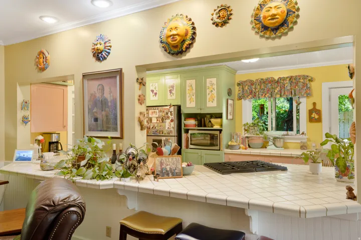 Kitchen with a tile countertop breakfast bar, integrated cooktop, recessed lighting, and pass-through windows