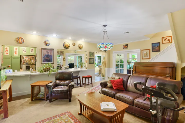 Spacious living area featuring neutral carpeting and a decorative ceiling light fixture