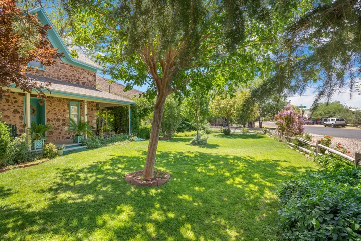 Expansive front lawn with mature trees and stone retaining ring