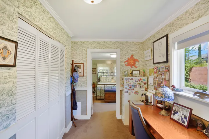 Hallway with patterned wallpaper and crown molding