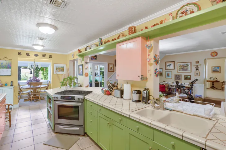 Kitchen featuring tile flooring, a built-in oven range, recessed lighting, tile countertops, and a double basin sink
