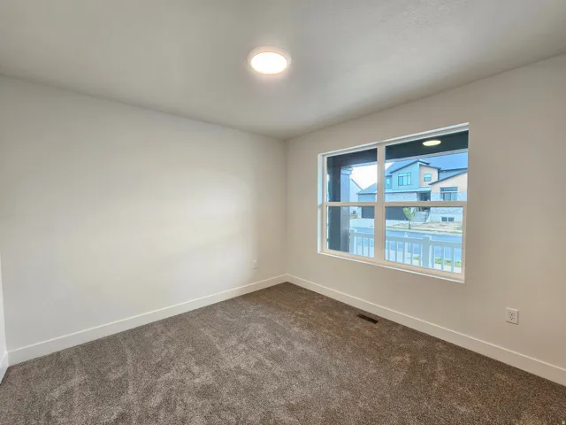 Neutral wall paint, plush carpeting, white trim, recessed lighting, and a multi-pane window
