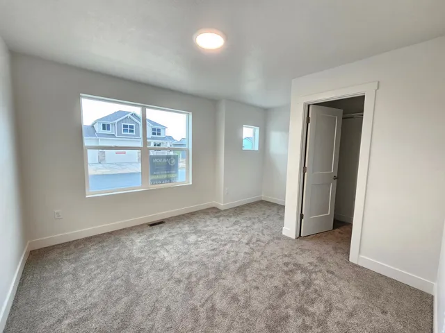 Plush grey carpeting, white interior walls, and a single ceiling-mounted light fixture