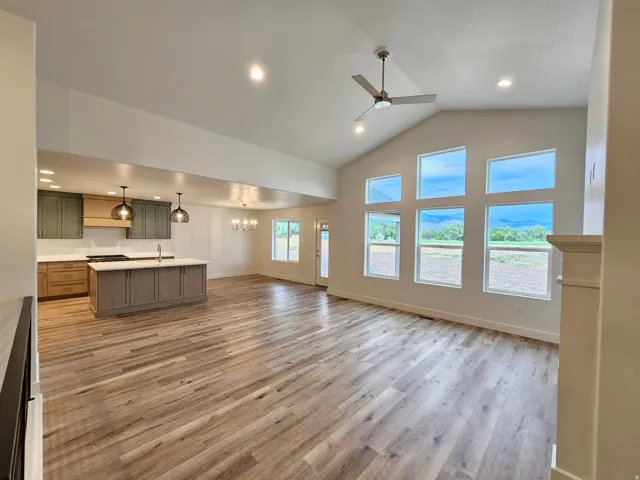 Vaulted ceiling with a contemporary ceiling fan, recessed lighting, and expansive windows
