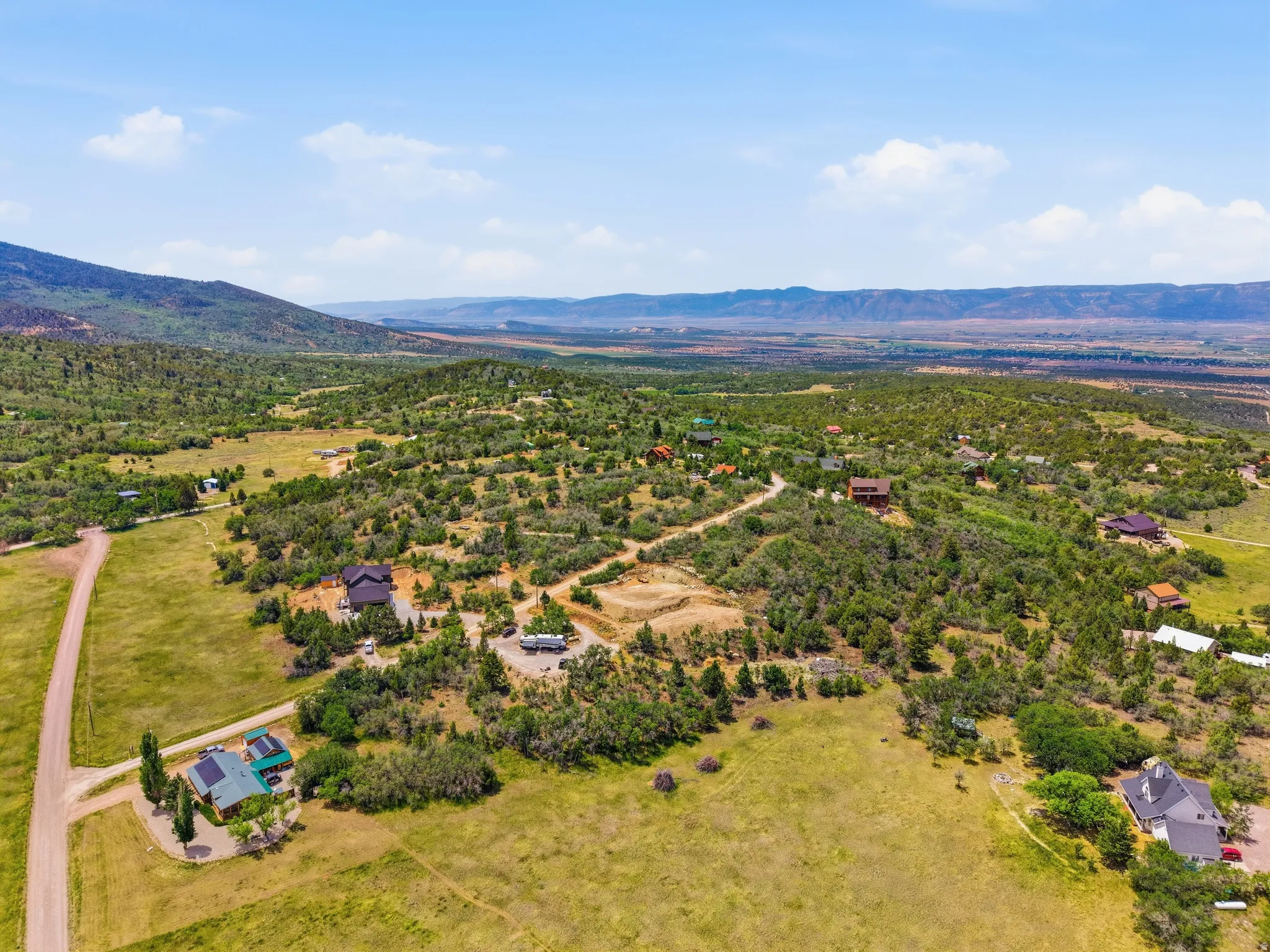 Expansive landscape featuring scattered residential properties, mature trees, and natural terrain