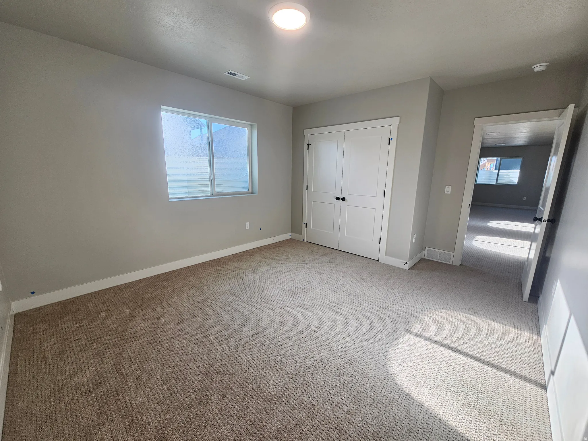 Spacious room featuring neutral carpeting and light gray walls