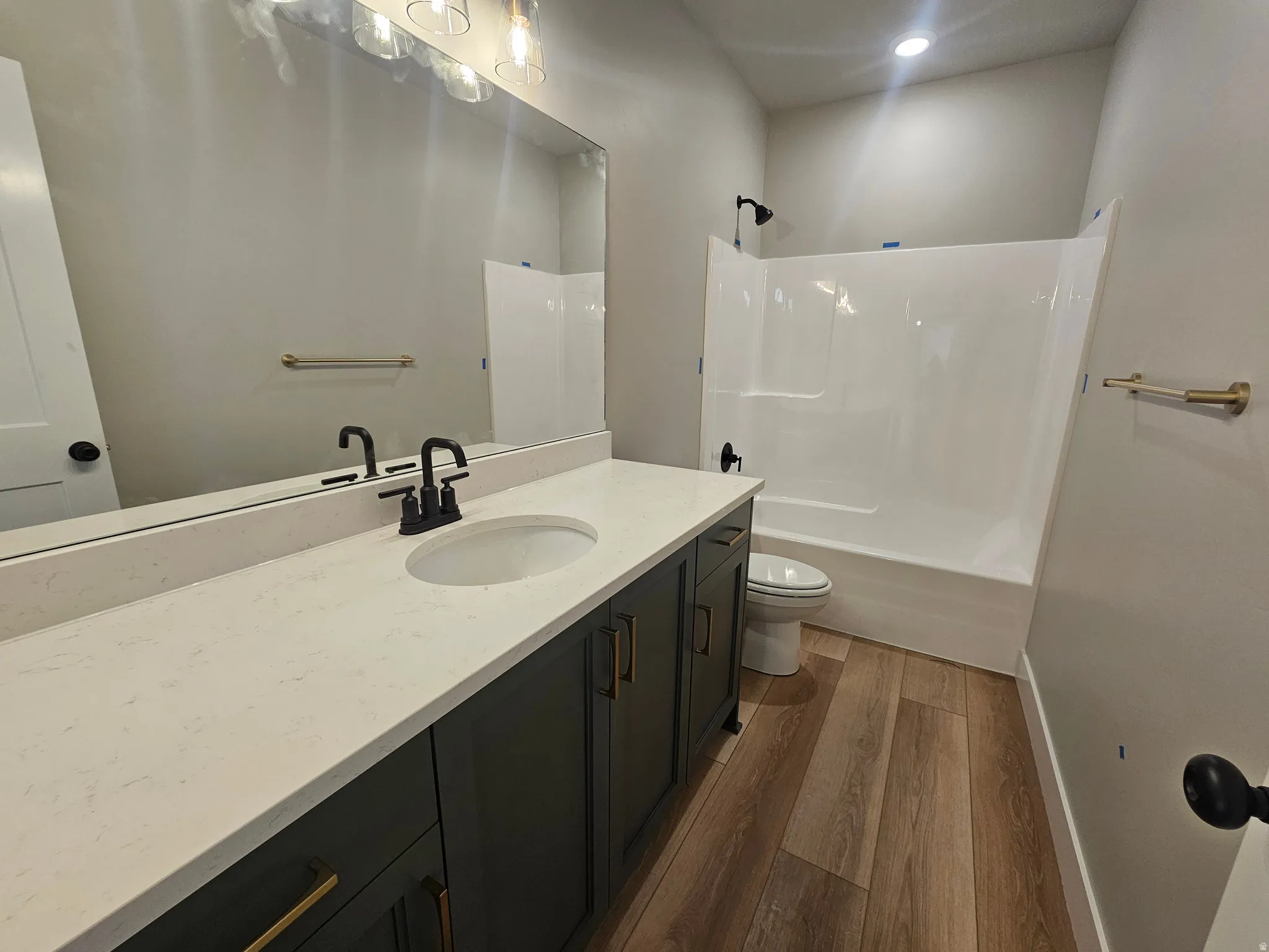 Bathroom featuring a dark wood-finish vanity with a light-toned countertop, an integrated sink, and matte black fixtures