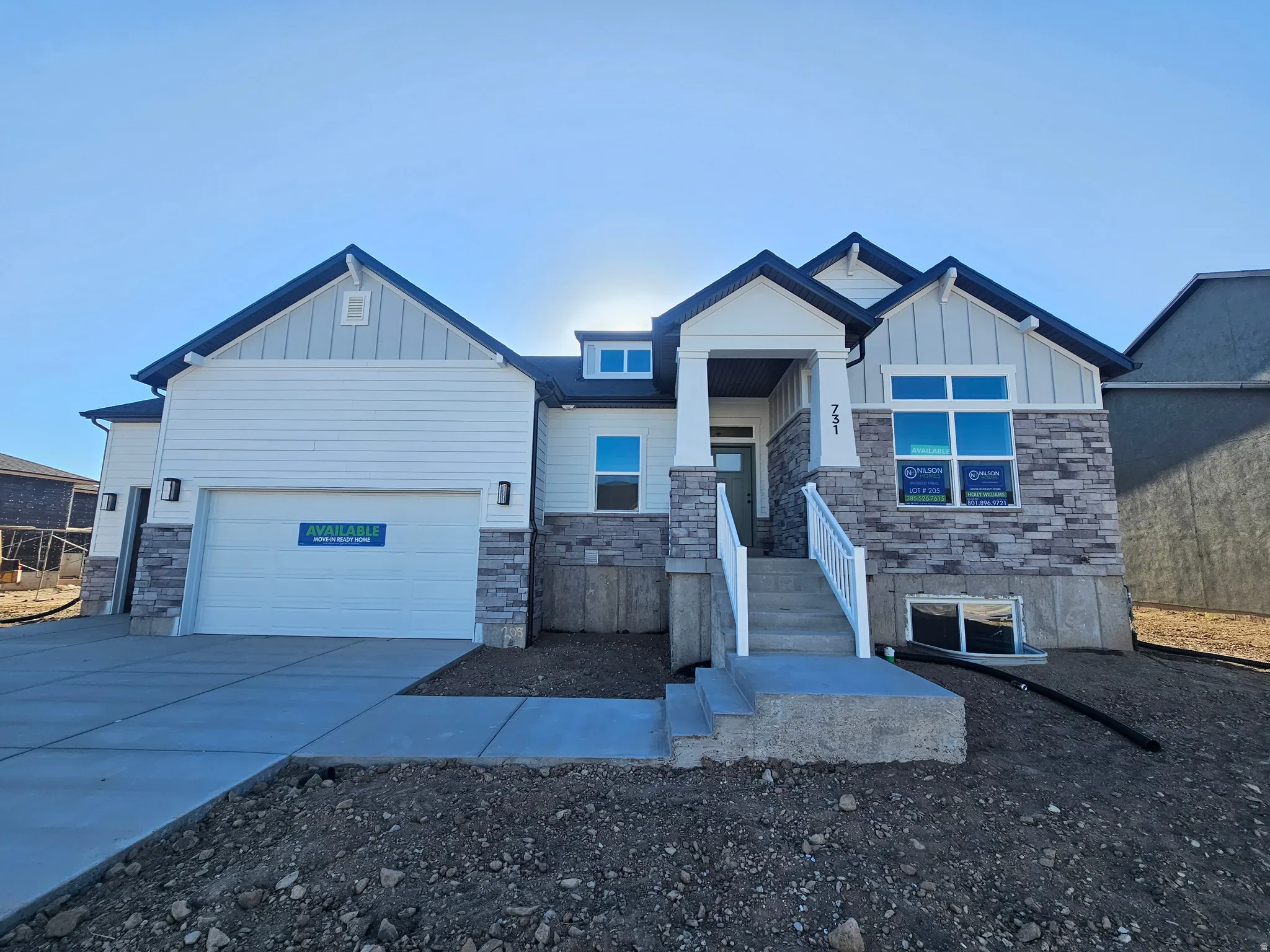 Contemporary home with white siding and stone veneer accents
