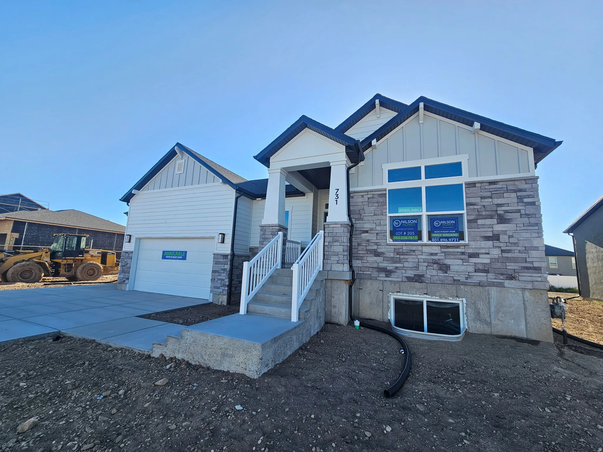 Contemporary exterior featuring a stone and siding facade, a covered front entry with white railings, an attached garage, and a concrete driveway