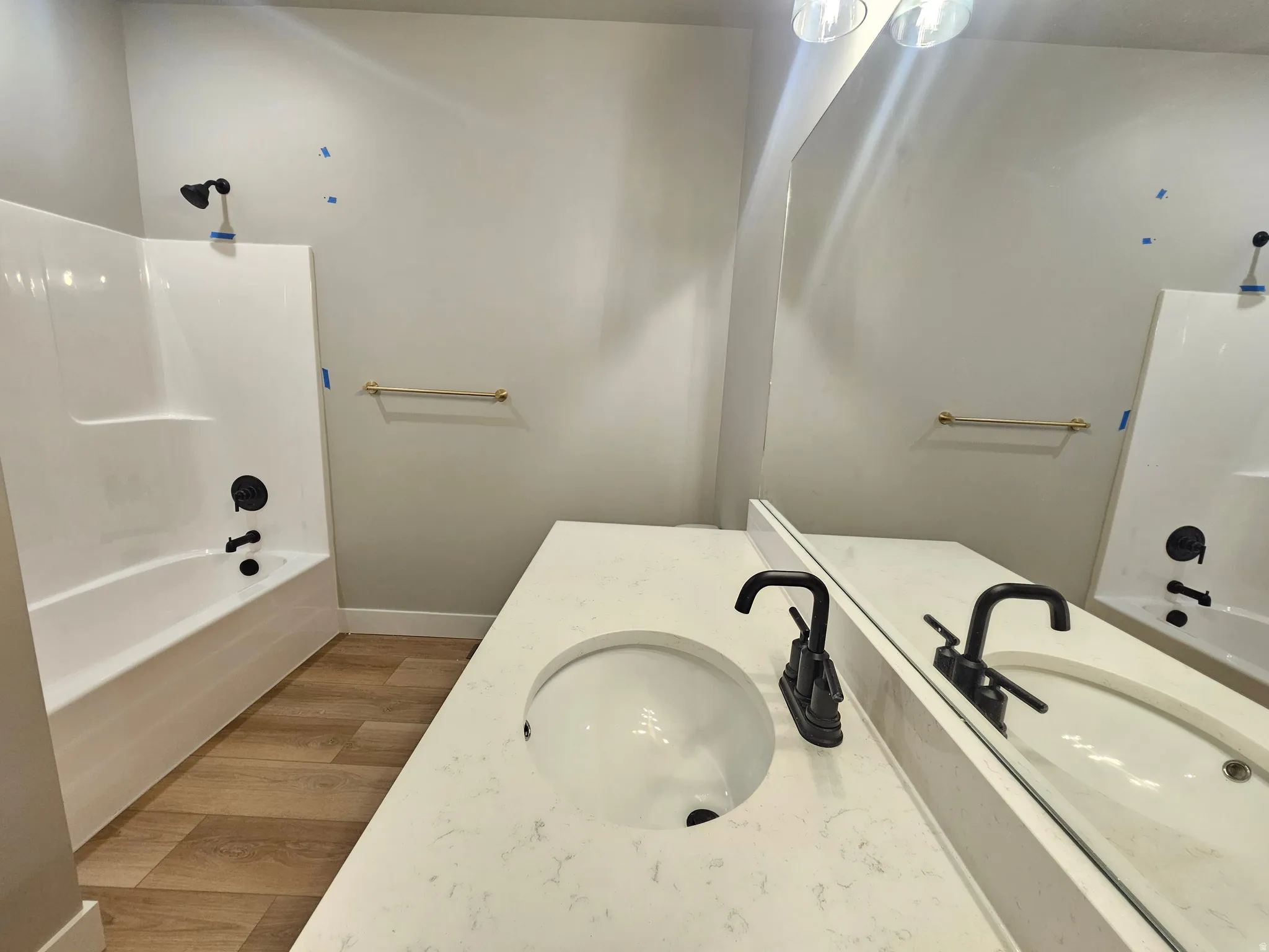 Bathroom vanity featuring a quartz countertop with an integrated sink and matte black faucet