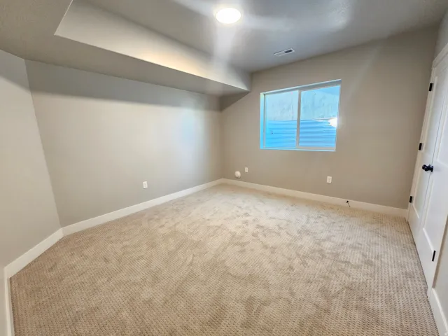 Carpeted room with neutral wall tones and a window