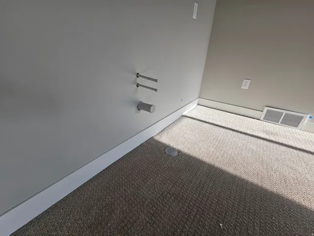 Textured wall-to-wall carpeting with white baseboards