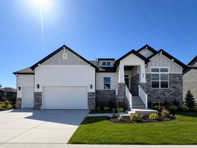 Contemporary residence featuring white siding, dark gray stone accents, a covered entry porch, a multi-pane window configuration, and an integrated two-car garage
