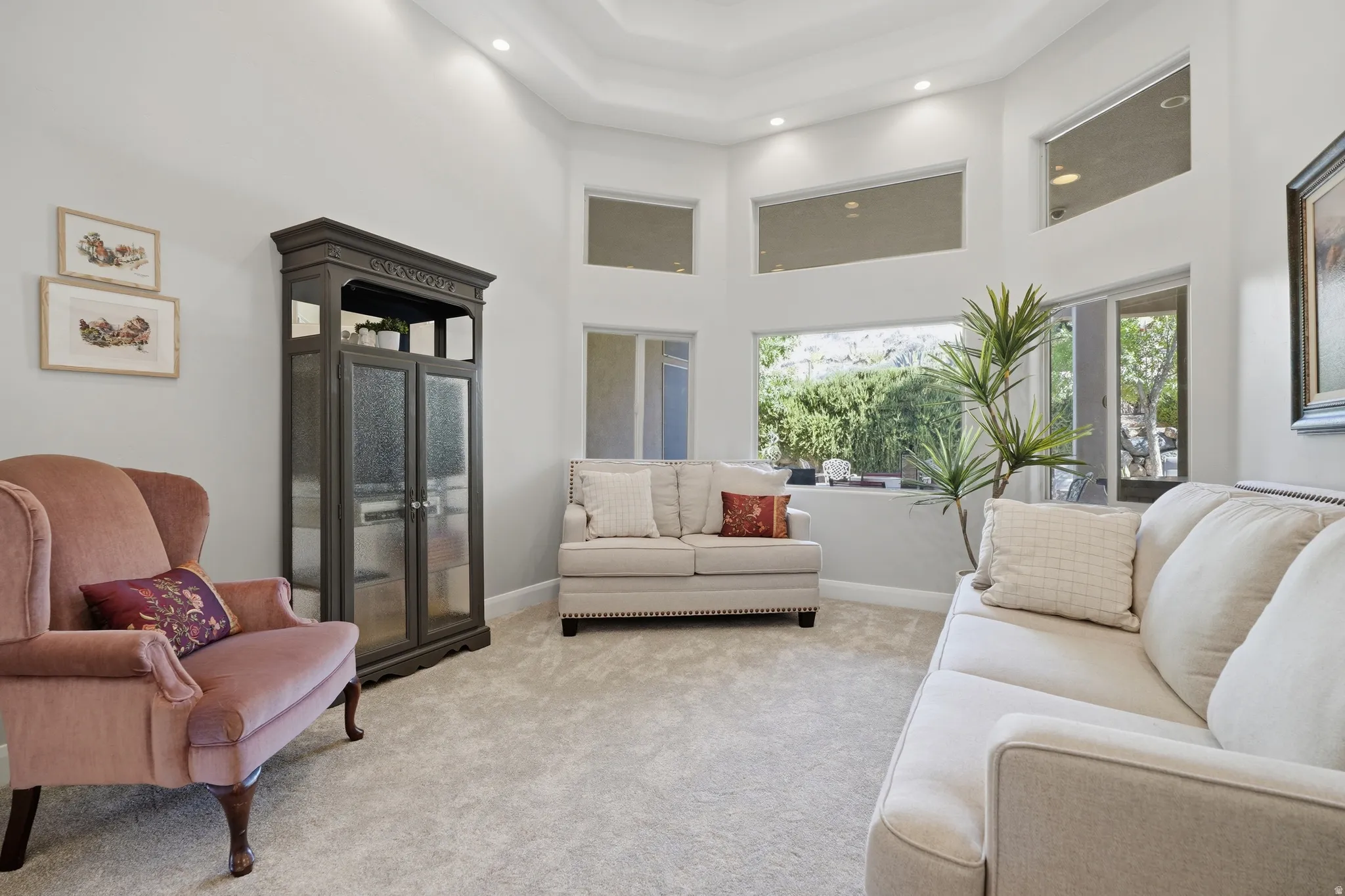 Spacious interior featuring high vaulted ceilings, recessed lighting, expansive windows, carpeted flooring, and light-toned wall finishes