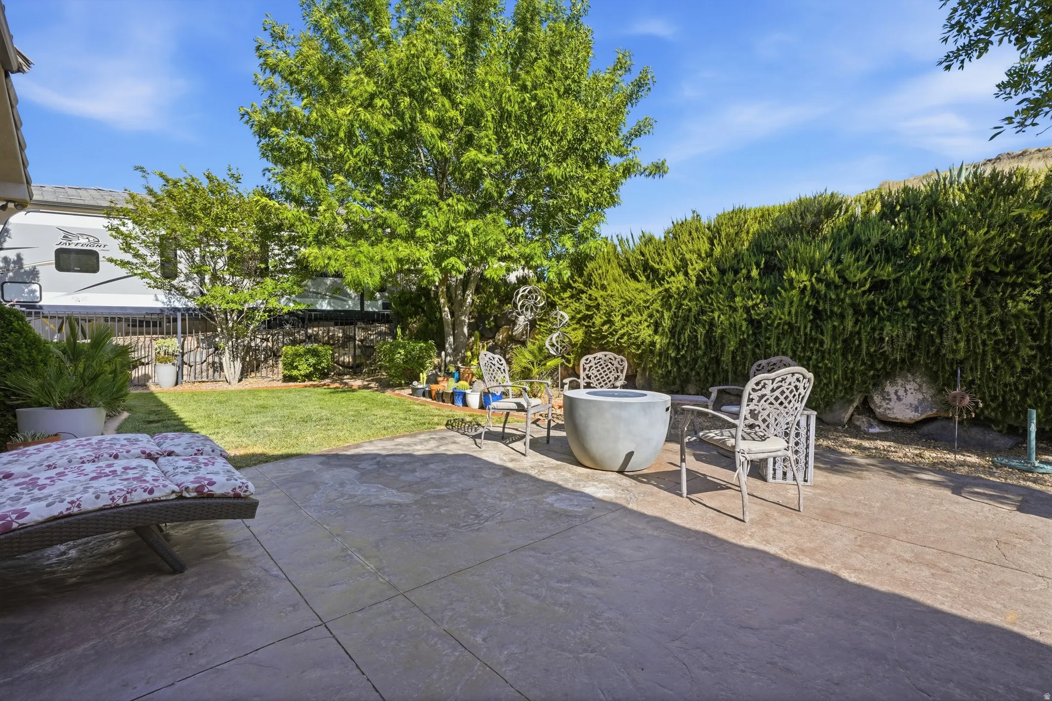 Spacious concrete patio featuring a built-in fire pit
