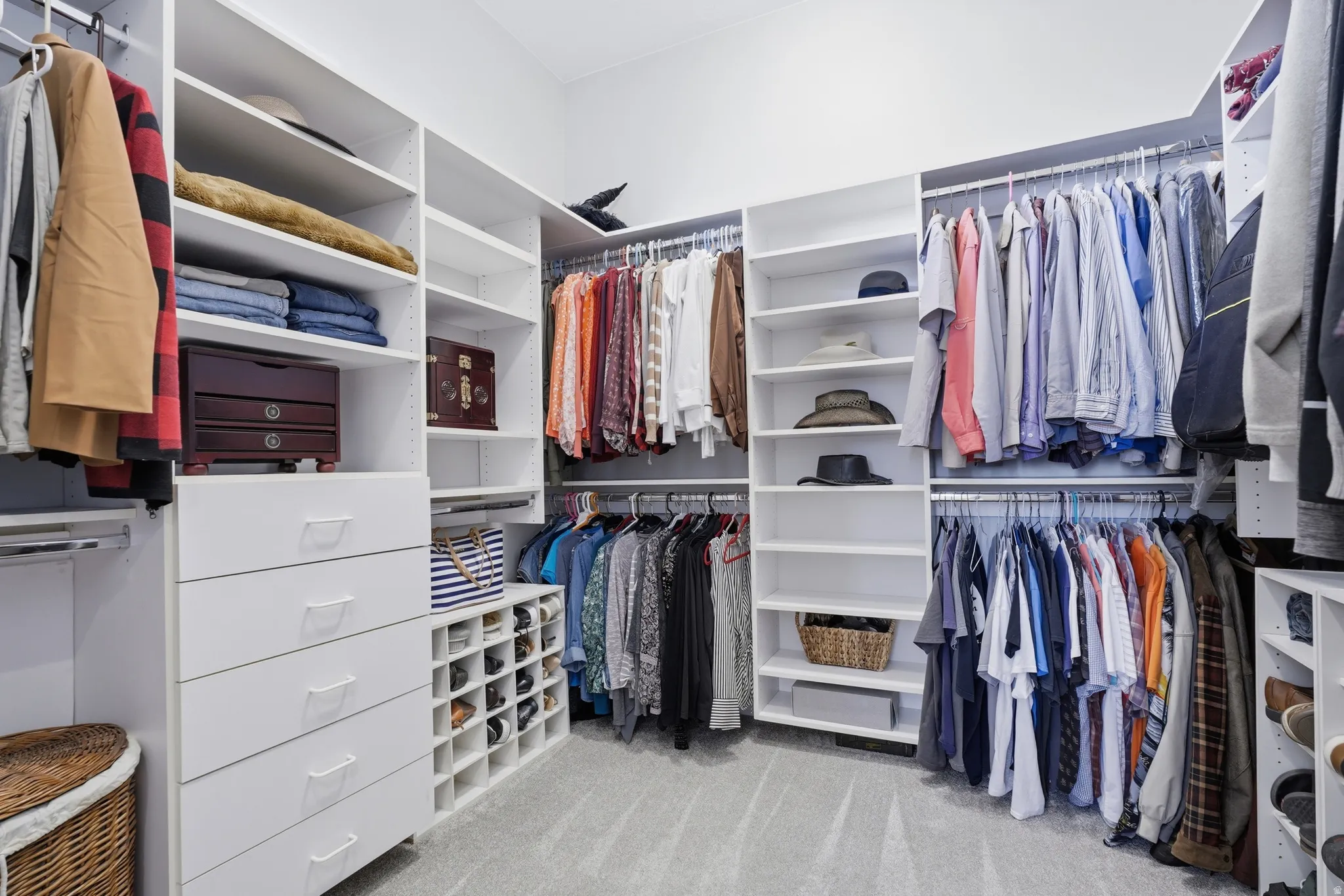 Custom closet system featuring multiple hanging rods, integrated shelving, built-in drawers, and dedicated shoe storage