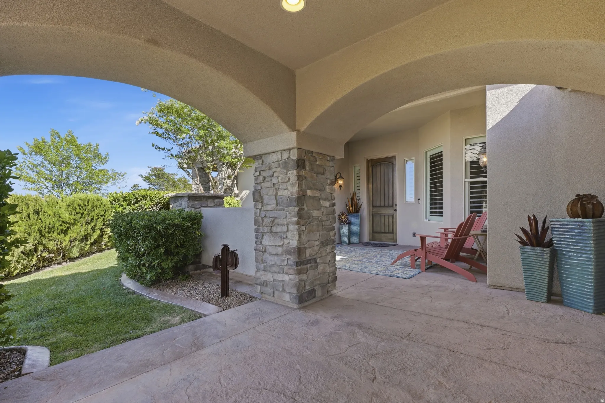 Inviting covered patio featuring arched ceiling details and a textured concrete surface