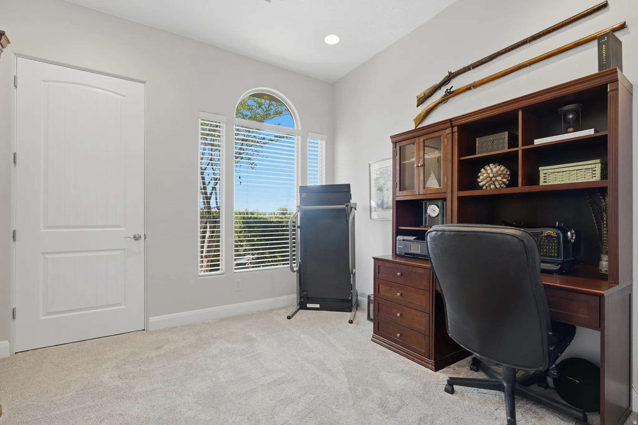 Carpeted room featuring a series of arched and rectangular windows