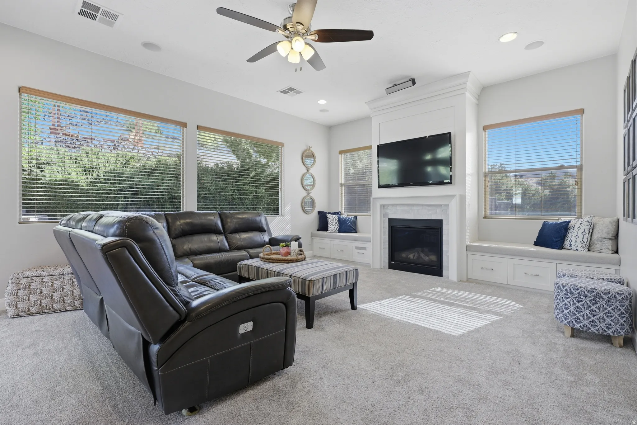 Spacious living area featuring a built-in fireplace with a white mantel, recessed lighting, and a ceiling fan