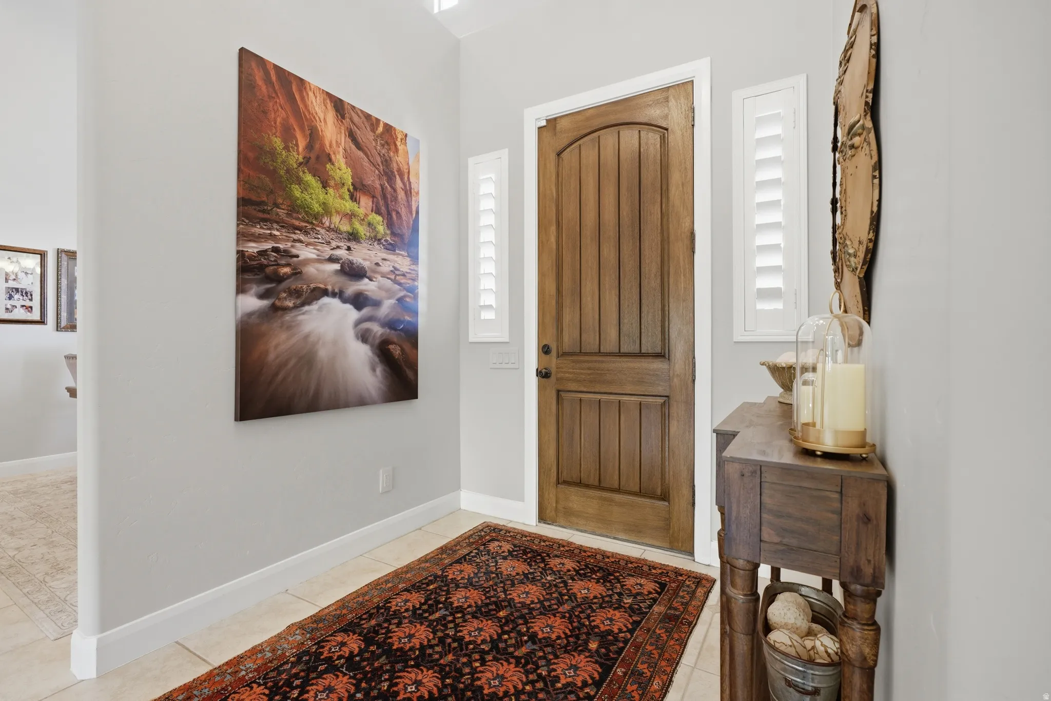 Wood-paneled entry door with an arched top, flanked by two vertical windows with plantation shutters