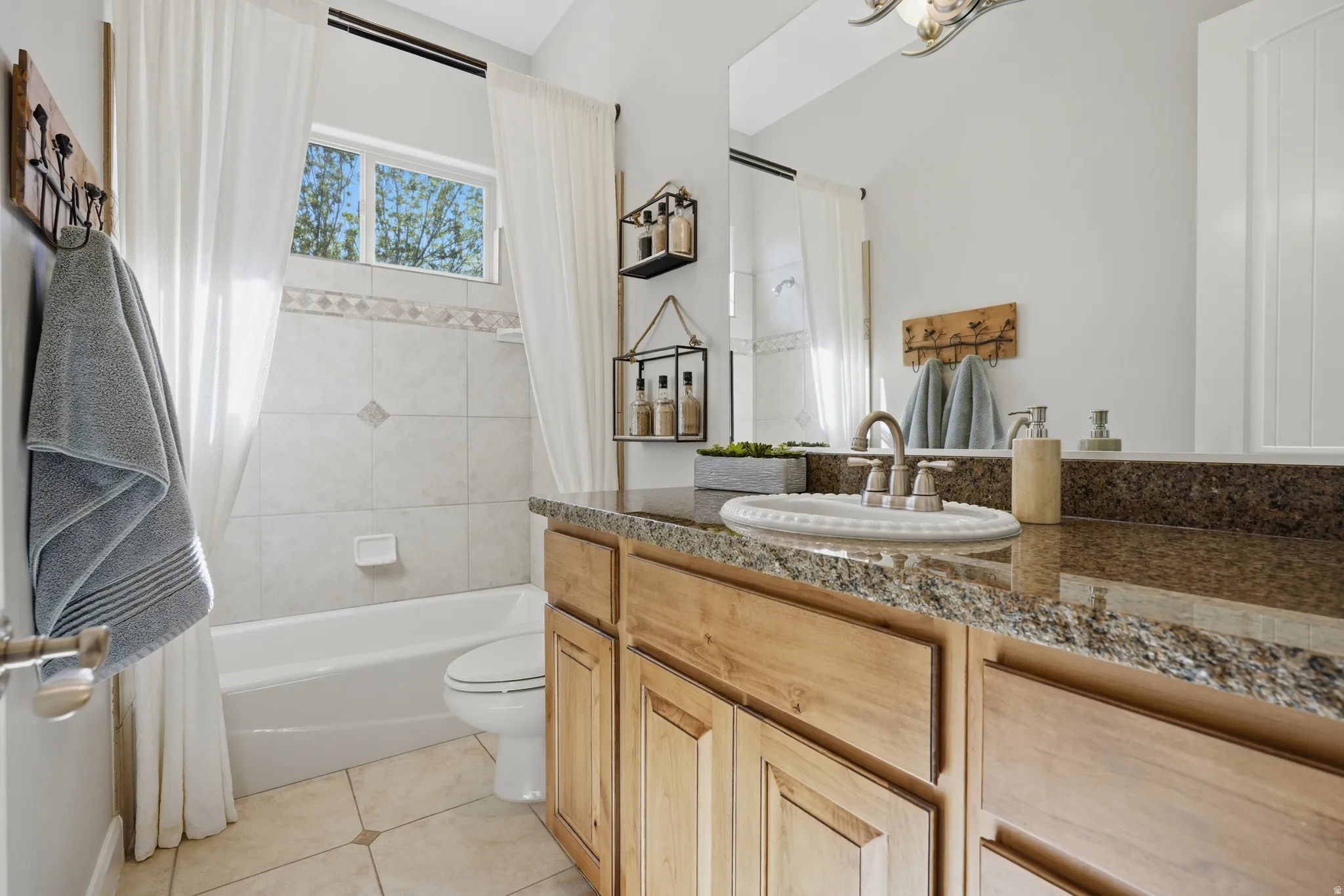 Bathroom featuring a wood vanity with a stone countertop, a white drop-in basin, and a brushed nickel faucet
