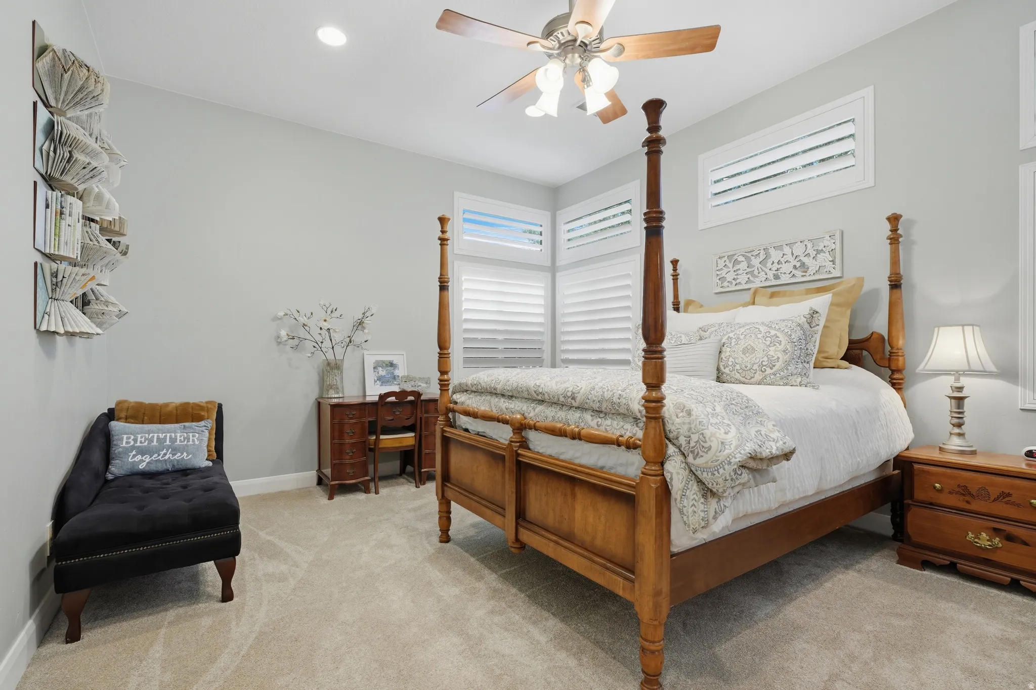 Carpeted room featuring multiple windows with louvered shutters, a ceiling fan with light fixture, and a recessed ceiling light