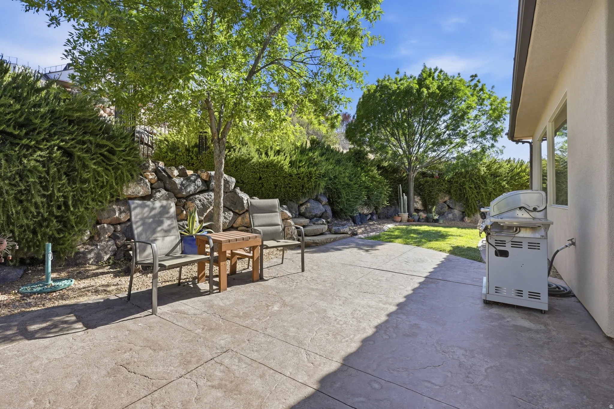 Expansive stamped concrete patio featuring direct access to a grassy yard