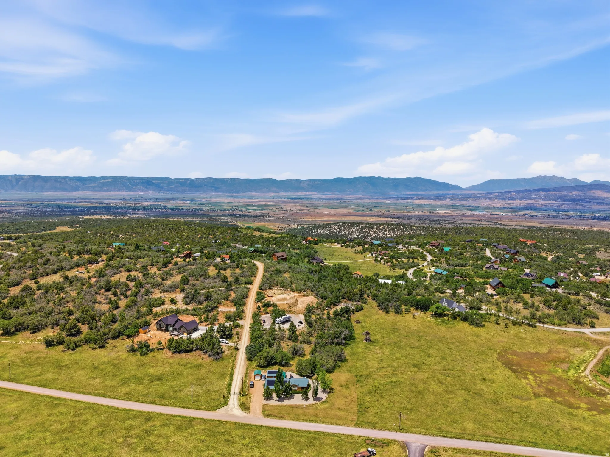 Expansive rural landscape featuring a network of unpaved roads and scattered residential structures