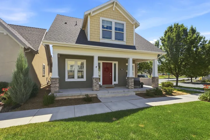 Inviting exterior featuring a prominent front porch with stone-clad columns