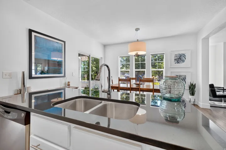 Kitchen island featuring a double basin stainless steel sink and a gooseneck faucet