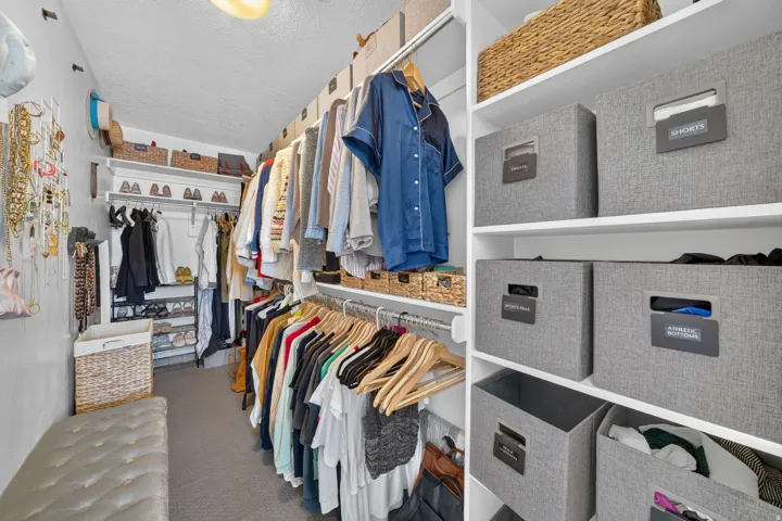Custom closet system featuring multiple hanging rods, integrated shelving, and a built-in shoe rack