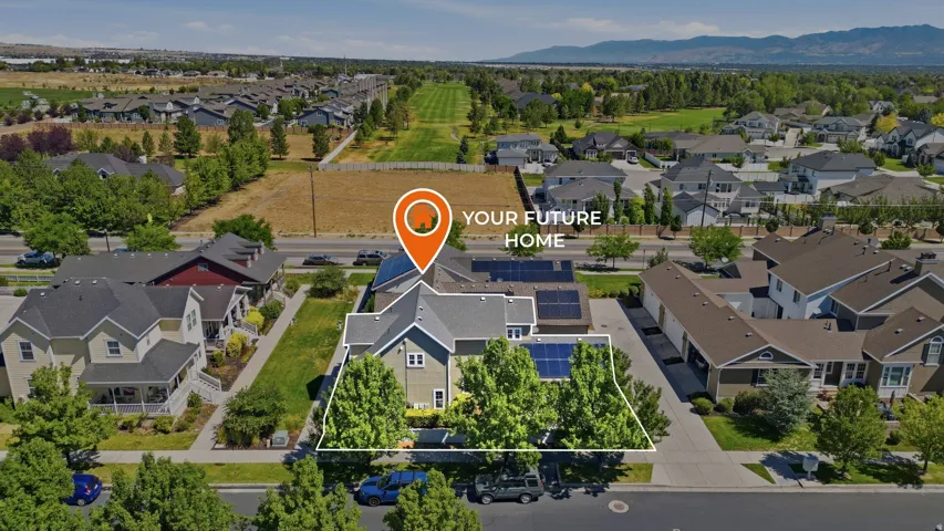 Aerial view showcasing a residential property with a gabled roofline and mature front yard trees
