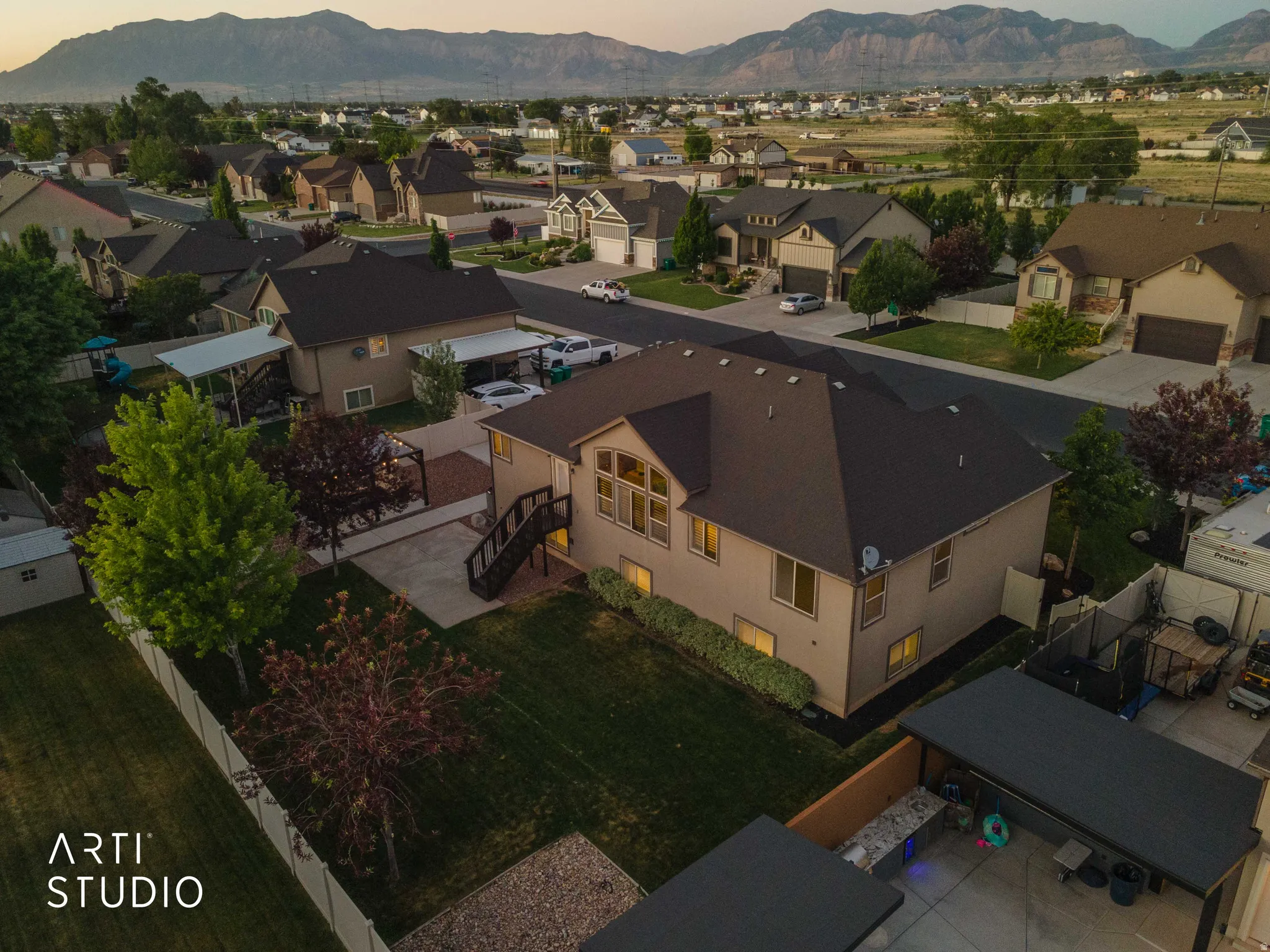Rear exterior featuring a spacious lawn, multi-level deck, and mature landscaping