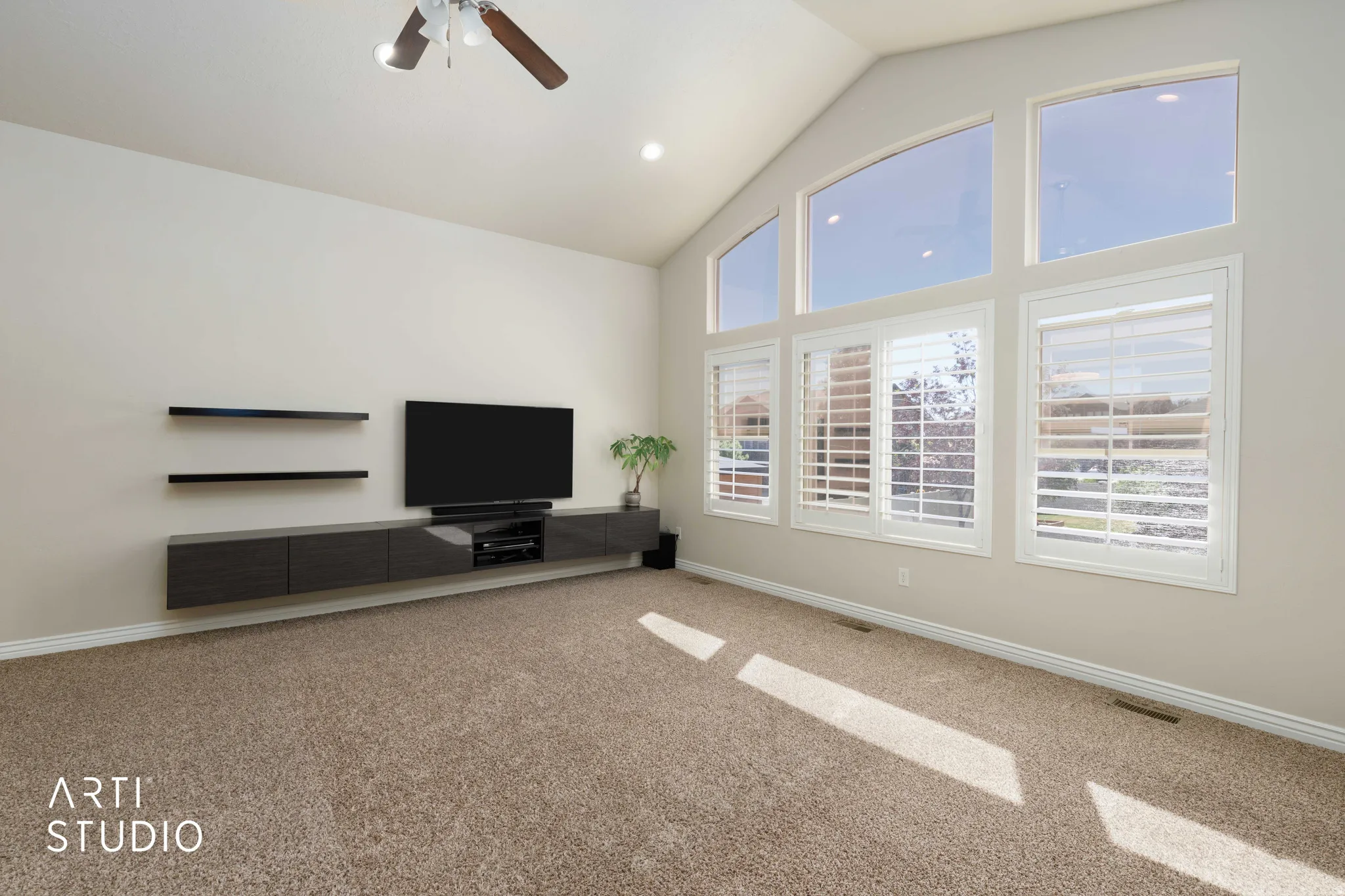 Living area featuring a vaulted ceiling and an array of large windows
