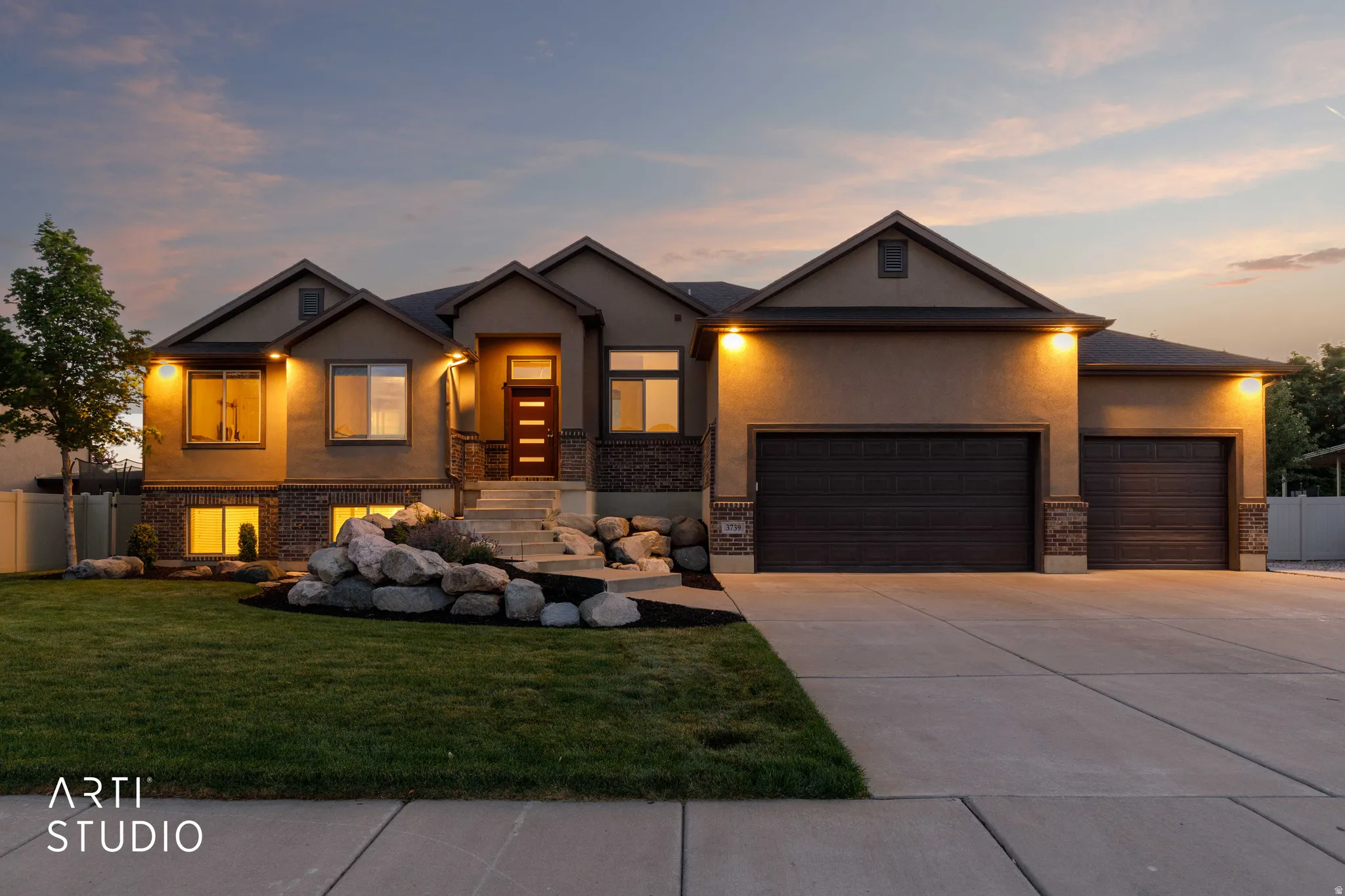 Two-story residence featuring a stucco and stone facade with multiple gables