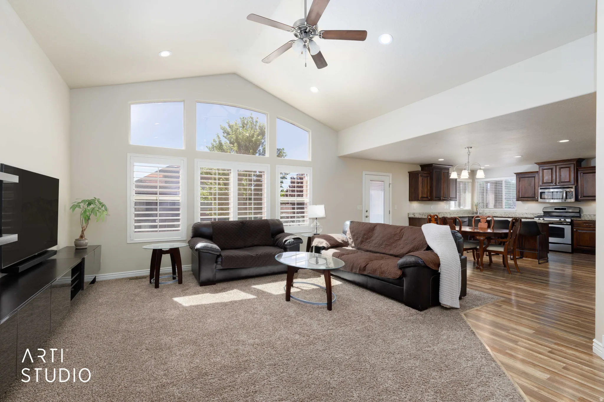 Living area featuring vaulted ceilings, recessed lighting, and a ceiling fan