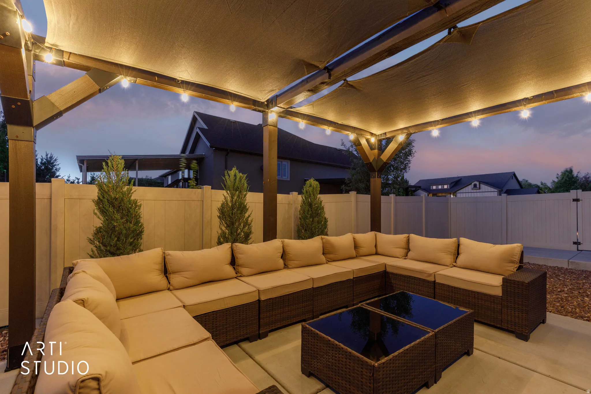 Outdoor patio featuring a pergola with a retractable shade canopy and integrated string lighting
