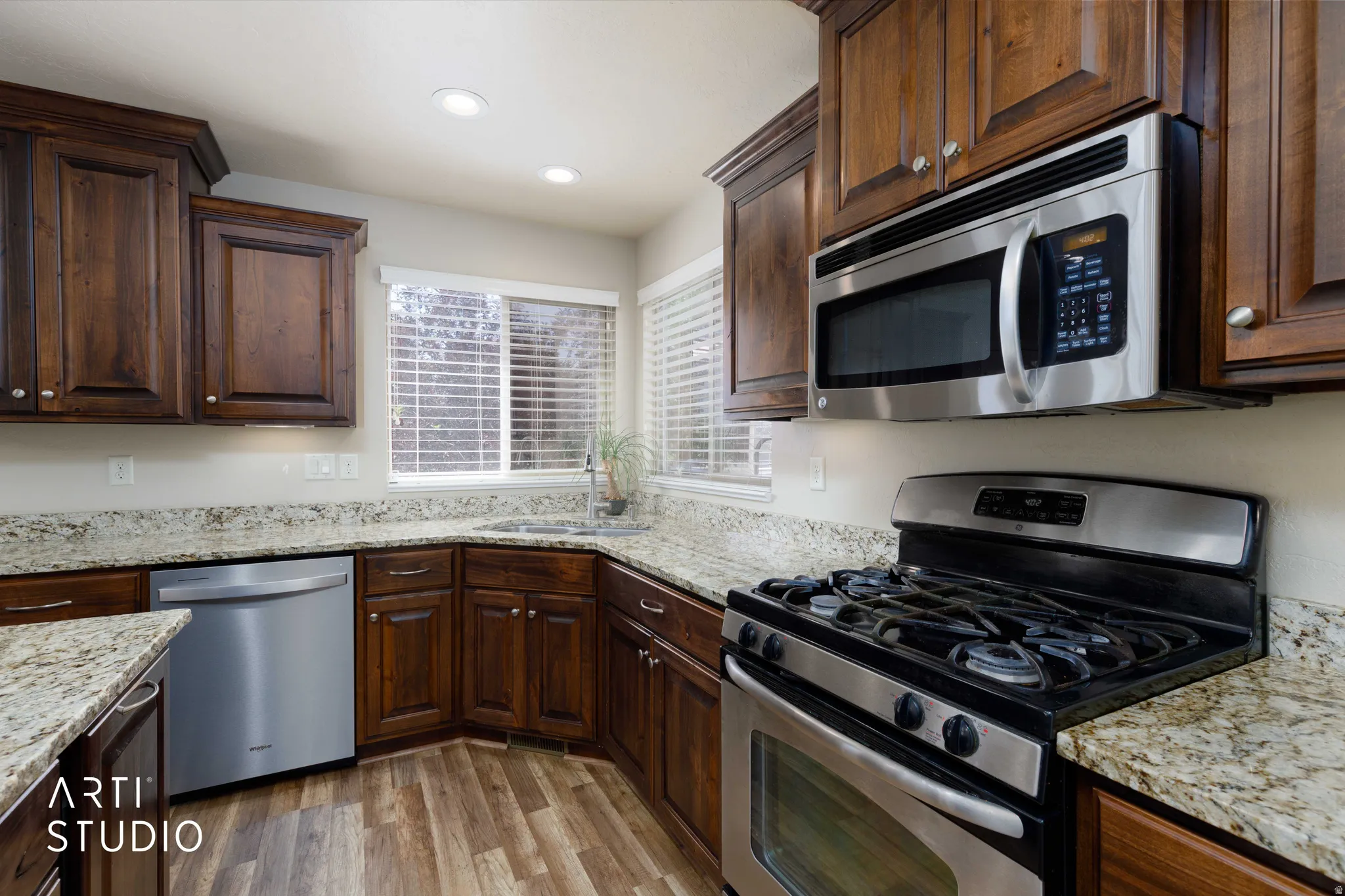Kitchen featuring stainless steel appliances, wood-finish flooring, recessed lighting, and ample cabinetry